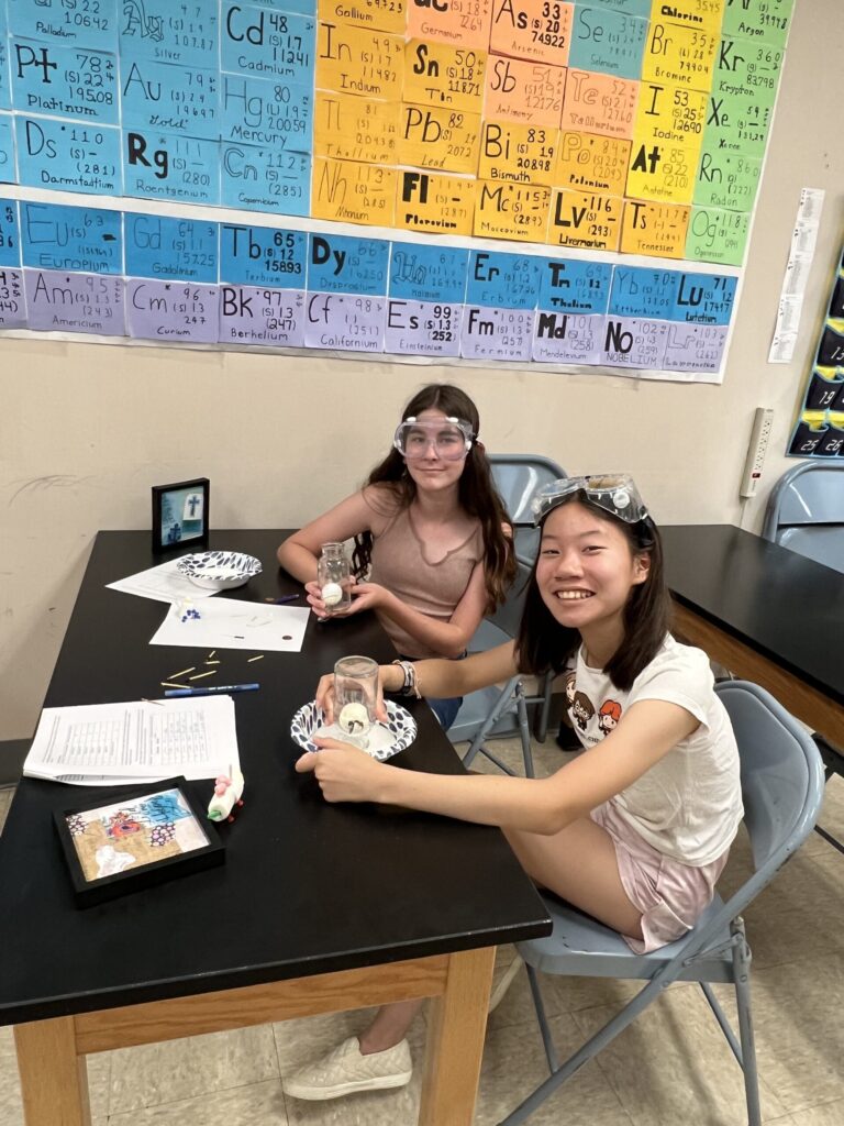 Girls doing science experiment at TCS summer quest